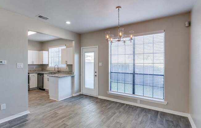 A well-lit, spacious kitchen and living room with a view of the outdoors.