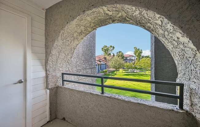 Model balcony with a view of a building and trees.