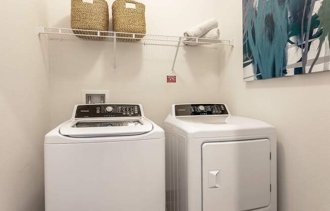 A white washing machine and dryer in a small laundry room.