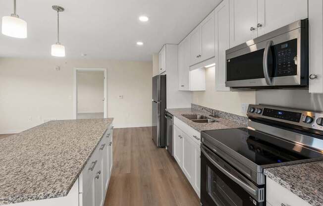A kitchen with granite countertops and stainless steel appliances.