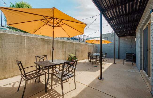 a patio with tables and chairs under umbrellas