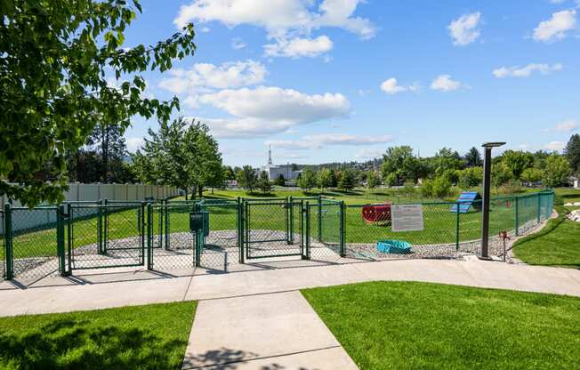 a fenced in area of a park with playground equipment