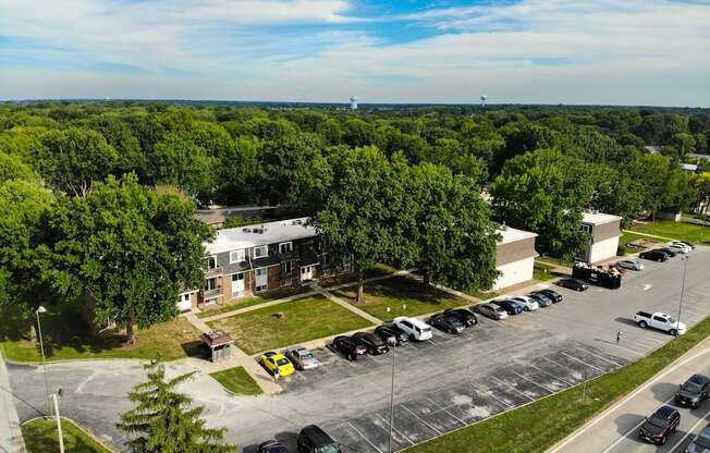 an aerial view of a parking lot with cars and buildings