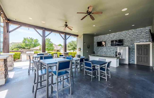A patio with a table and chairs and a ceiling fan.