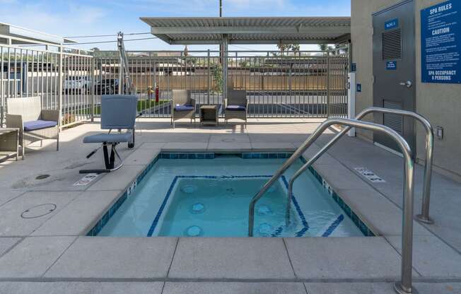 a hot tub with a metal railing in front of a building at Loma Villas Apartments, San Bernardino