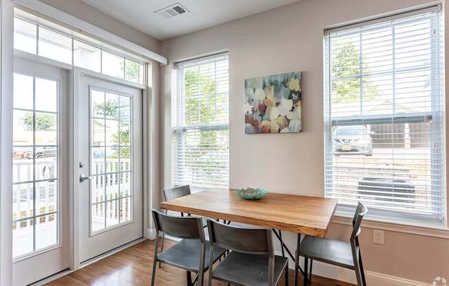 A dining room with a table and chairs.