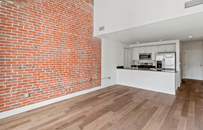 Experience urban elegance with this stylish open-concept kitchen and exposed brick feature wall.