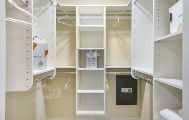a walk in closet with white shelving and shelves and a door at Aster Apartments, Beachwood, 44122