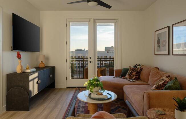 Natural light, warm finishes, and a private balcony view create a living space that feels both refined and inviting.