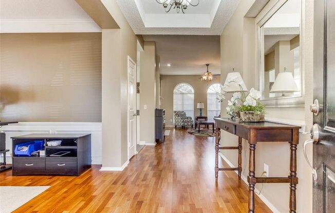 This charming 3-bedroom, 2-bath home in Frisco, TX, boasts elegant hardwood floors throughout, enhancing its warm and inviting atmosphere.