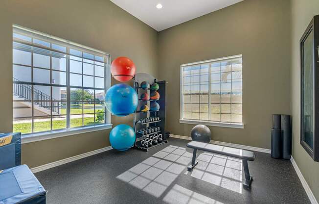 A room with a large window, a bench, and exercise equipment.