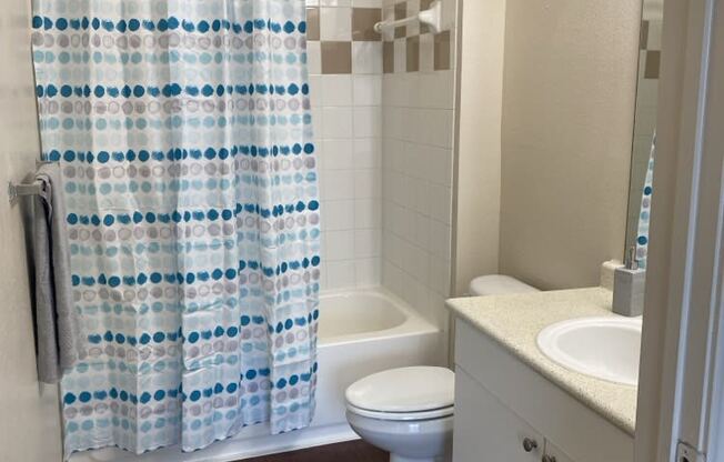 a bathroom with a shower curtain and a toilet