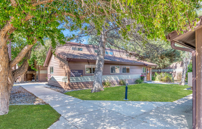 a house with a sidewalk and trees in front of it