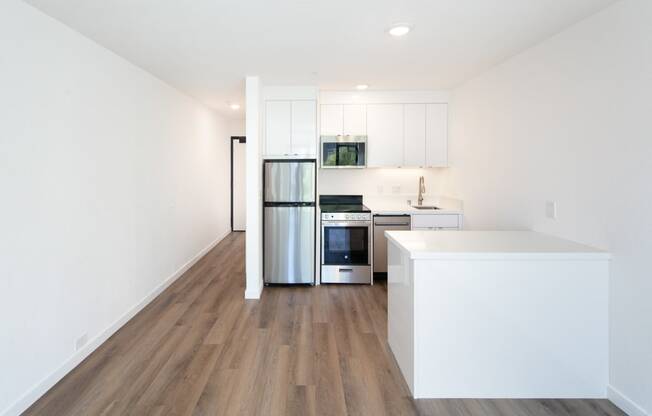 a kitchen with white cabinetry and a wooden floor