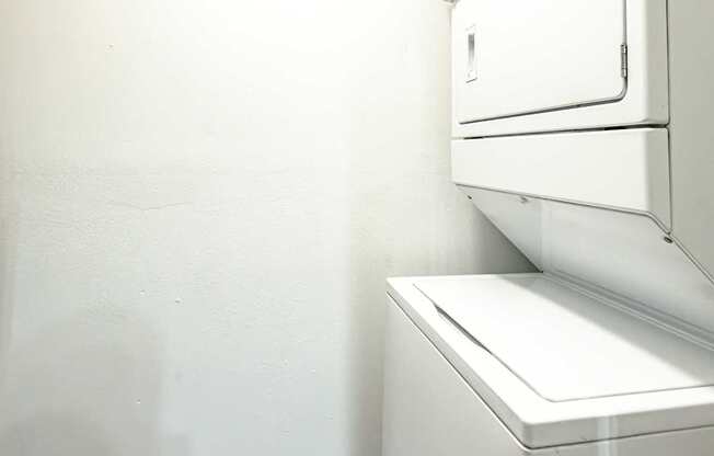 An in-unit white washer and dryer in a small room at Mandarin Bay Apartments.