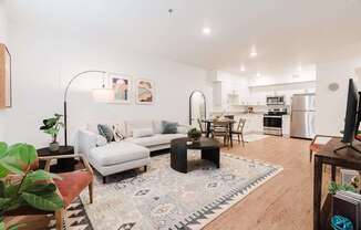 A living room with a white couch and a rug with a geometric pattern.