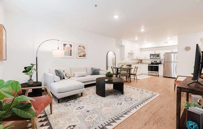 A living room with a white couch and a rug with a geometric pattern.