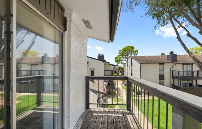 a view from the balcony of a house with a yard and a tree