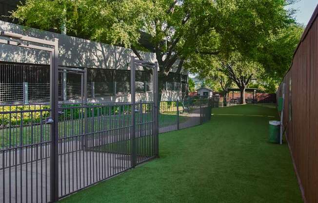 A metal fence surrounds a green field.
