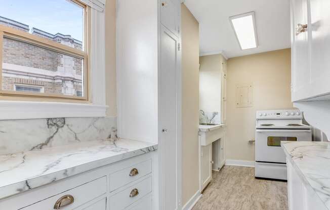 Fully-Equipped Kitchen  with Marble Look Countertops, A Window, and Stove Oven at Malloy Apartment Homes, Seattle, WA