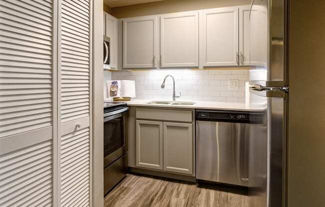 a kitchen with stainless steel appliances and white cabinets