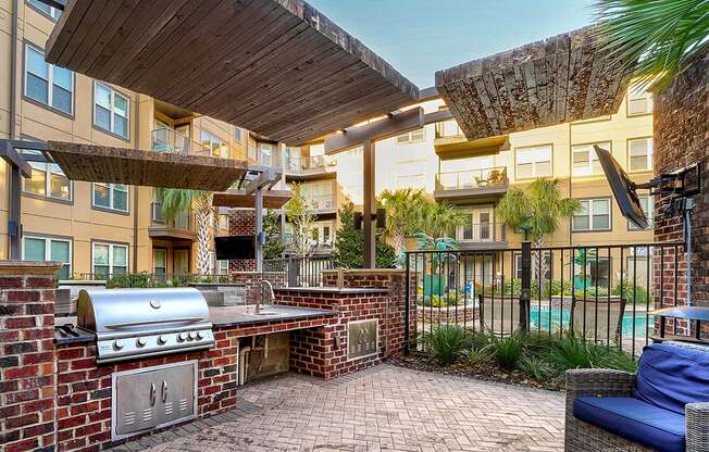 A patio with a grill and seating area.