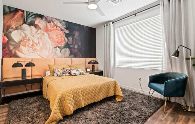 a bedroom with a bed and a large painting of flowers