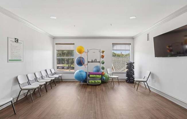A fitness center with weights, yoga equipment, and a TV at Encore at Buckingham Apartments in Richardson, TX