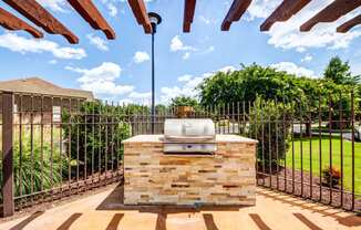 the backyard has a grill and a barbecue area with a fence
