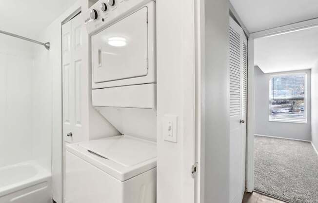 A white oven and microwave are built into a wall in a kitchen.