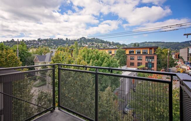 a balcony with a view of the city and trees