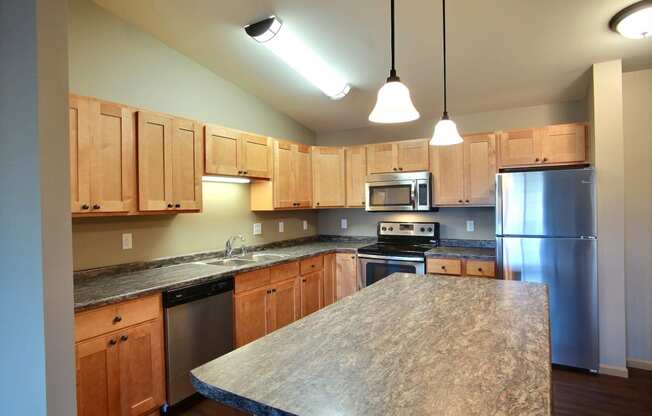 a kitchen with stainless steel appliances and granite counter tops. Fargo, ND Urban Plains Apartments