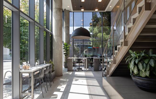 a dining room with large windows and a staircase