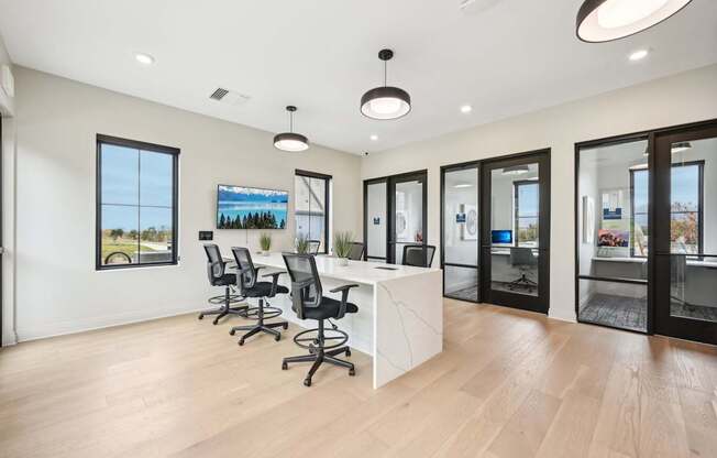 a conference room with a desk and chairs in front of a window