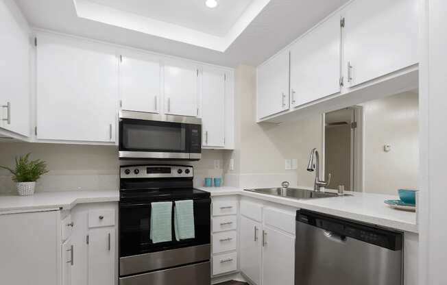 a kitchen with white cabinets and black and white counter tops at Huntington Terrace North Senior, Huntington Beach California
