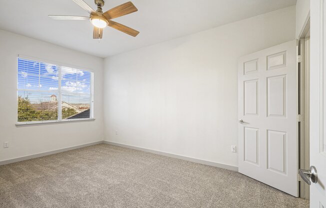 an empty living room with a ceiling fan and a window at The Legends at Eagle Mountain Lake, Fort Worth, Texas