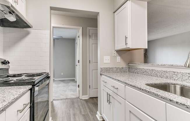 a kitchen with granite counter tops and white cabinets