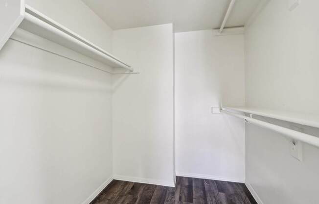 A white room with a wooden floor and a white door.