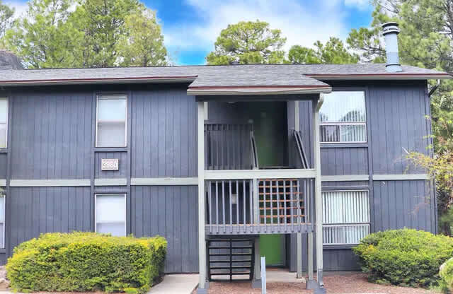A two-story building with a balcony and a green door.