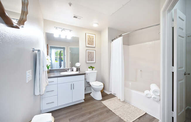 A bathroom with a toilet, sink, and bathtub.