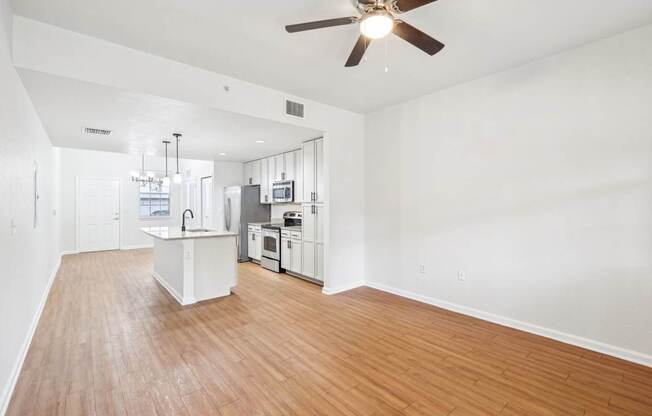 A kitchen with white cabinets and a wooden floor.