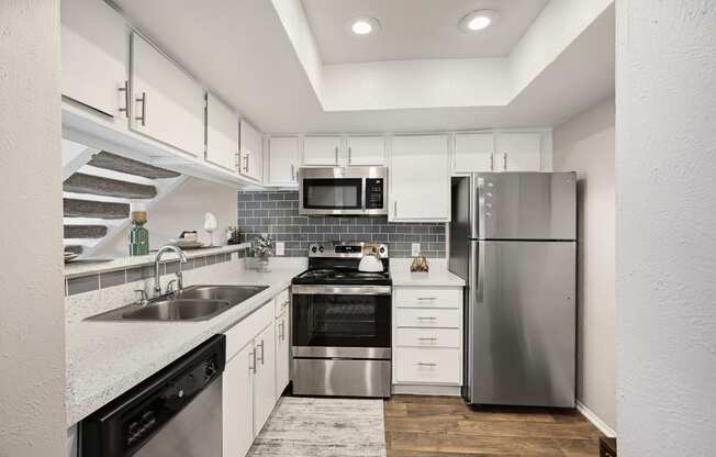 a kitchen with white cabinets and stainless steel appliances