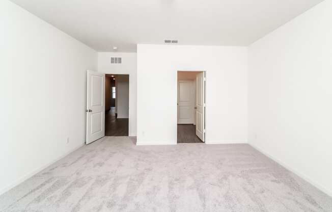 a bedroom with white walls and carpet