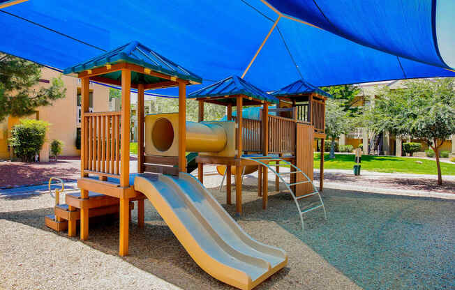 a childrens playground with a slide and playset