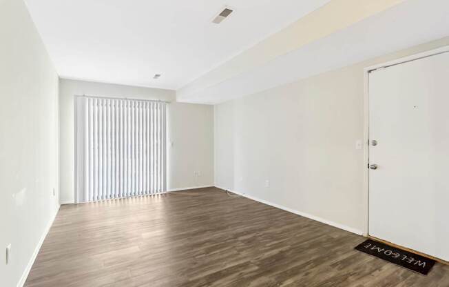 A room with wooden flooring and a white door.