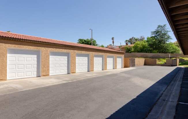 a row of garages with white garage doors on a brick building