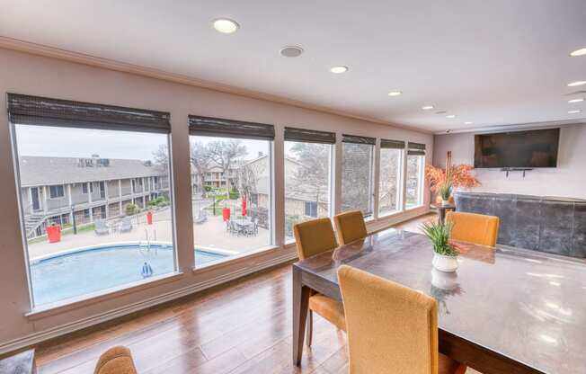a dining room with a large window overlooking a swimming pool