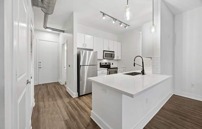 A kitchen with white cabinets and a white countertop.