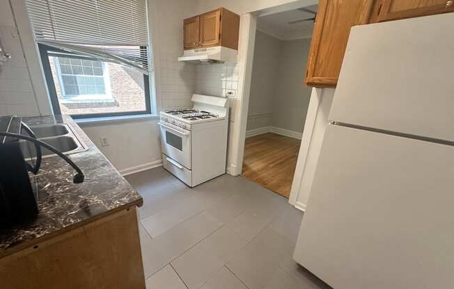 a kitchen with a stove refrigerator and a window