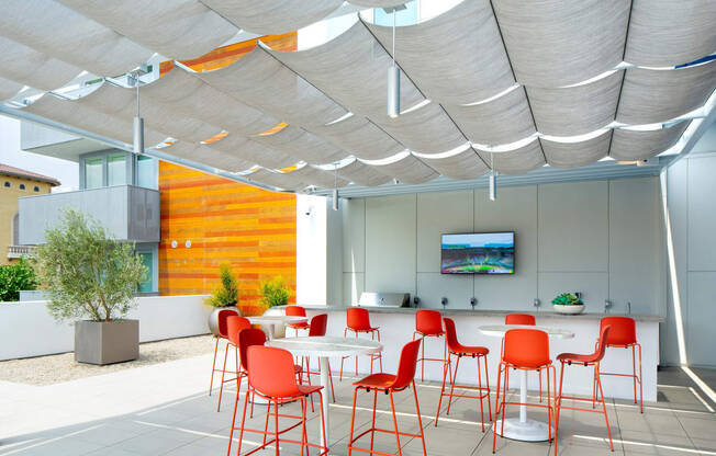 a dining area with red chairs and tables under a white canopy